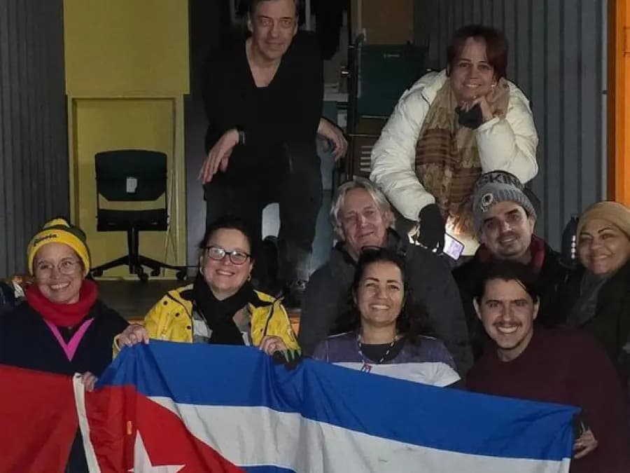 Voluntarios con la bandera cubana dentro del contenedor de material médico cargado en Lausana